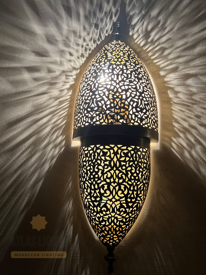Decorative wall light with intricate patterns on a textured wall.