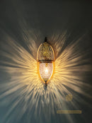 Decorative wall sconce casting a warm glow on a dark background