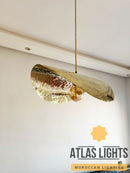 Gold pendant light fixture hanging from the ceiling with 'Atlas Lights' branding.