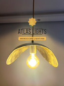 Moroccan-style pendant light with glowing bulb, branded 'Atlas Lights'.