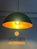 Green pendant light with gold interior, branded as Atlas Lights, on a dark background.