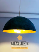 Dark green pendant light with gold interior on a white ceiling, featuring 'Atlas Lights' branding.